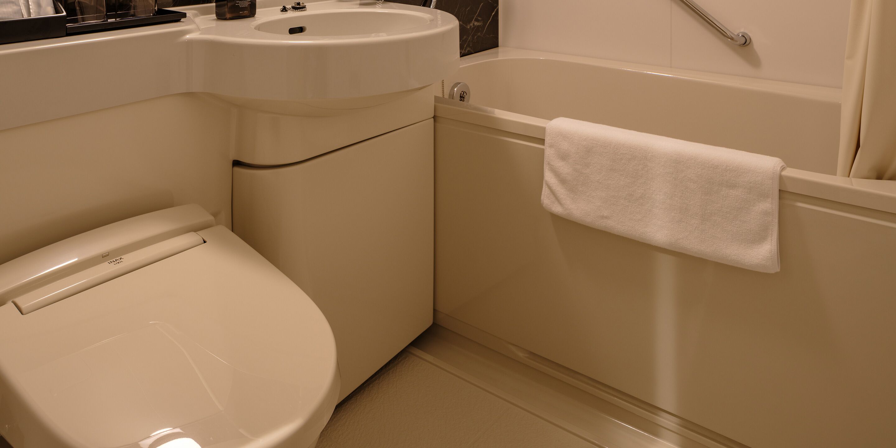 A bathroom with a toilet, sink, and bathtub.