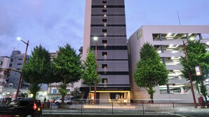 A multi-story hotel with a modern facade, a visible entrance, and a parking structure adjacent to it. - HOTEL SUI HAMAMATSU (Hamamatsu)