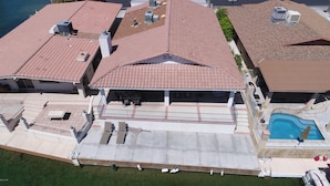 An aerial view of a residential property with multiple buildings, a swimming pool, and outdoor seating areas. - Parker Keys--Two Houses from the River (Parker)