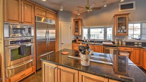 A modern kitchen with stainless steel appliances, wooden cabinets, and a granite countertop. - Parker Keys--Two Houses from the River (Parker)