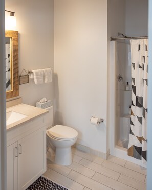A bathroom with a toilet, sink, and shower.