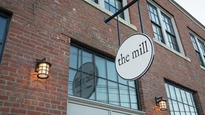 Un edificio de ladrillo con un letrero que dice "the mill".