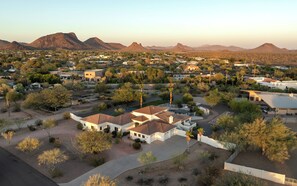 A residential area with houses, trees, and mountains in the background.