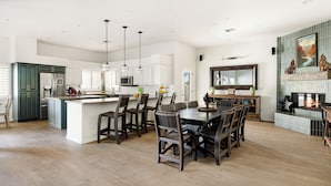 Una cocina amplia con una isla central, sillas de madera oscura y una mesa de comedor.