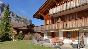 Un chalet doté d’un balcon, d’un espace extérieur aménagé et offrant une vue sur les montagnes.