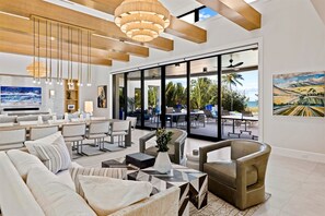 Amplia sala de estar con televisor grande, asientos cómodos y vistas al exterior.