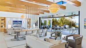 A spacious living area with a large dining table, comfortable seating, and a view of the outdoors. - Bella Luna ~ Ultimate luxury awaits (Captiva)