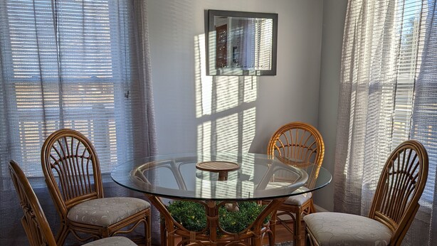 A dining area with a round glass table surrounded by four wicker chairs, a patterned rug, and a ceiling fan. - Mountain Views, River fun, Hiking, Biking, Breweries, Golf, and Wineries galore (Jonesville)