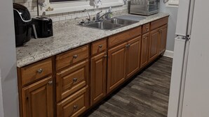 A kitchen with wooden cabinets, a granite countertop, a microwave, and a sink. - Mountain Views, River fun, Hiking, Biking, Breweries, Golf, and Wineries galore (Jonesville)