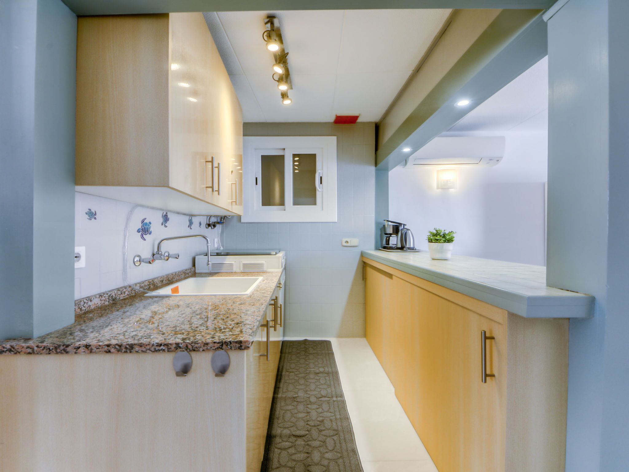 A modern kitchen with a granite countertop, stainless steel appliances, and wooden cabinets.