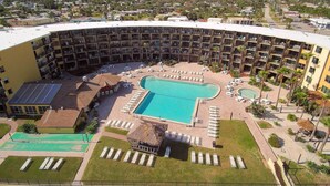 Ein Hotel mit großem Pool, mehreren Balkonen und Blick auf die Umgebung.