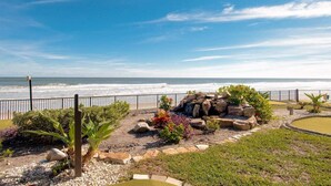Ein angelegter Garten mit Blick auf das Meer, der einen Felsengarten, verschiedene Pflanzen und einen gepflasterten Weg zeigt.