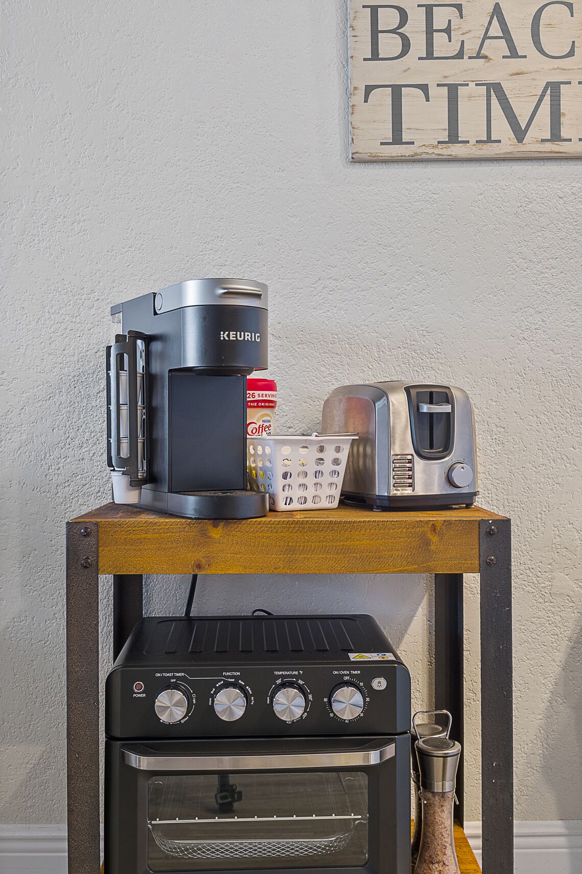 A kitchen counter with a Keurig coffee maker, a toaster, a coffee can, and a portable oven.