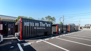 A hotel with a modern design, featuring a black exterior and red accents. It includes multiple rooms and a parking lot. - HOTEL R9 The Yard Hitachinaka (Hitachinaka)
