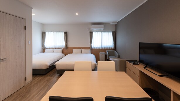 A modern hotel room with two beds, a TV, a desk, and a chair. - HOTEL R9 The Yard Hitachinaka (Hitachinaka)