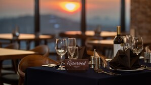 Ein gedeckter Tisch mit einem 'Reserved'-Schild, Weingläsern und einer Weinflasche.
