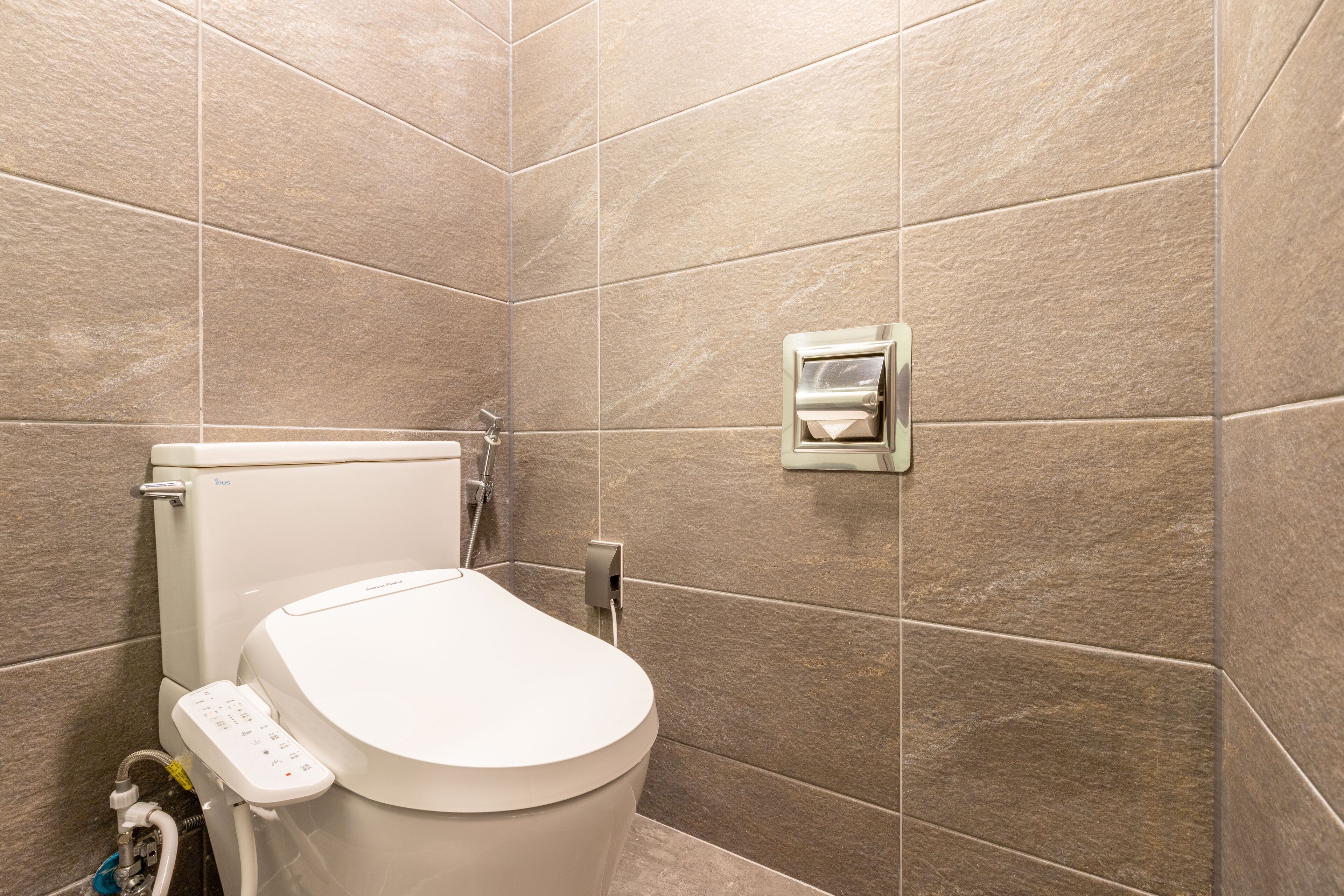 A modern bathroom with a toilet, a bidet, and a wall-mounted bidet.
