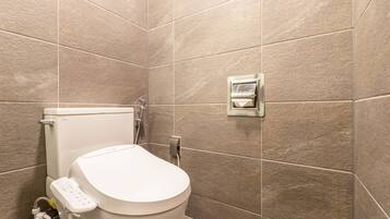 A modern bathroom with a toilet, a bidet, and a wall-mounted bidet.