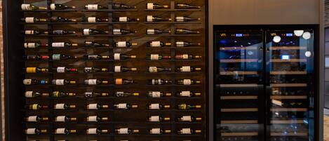 A wine cellar with multiple rows of wine bottles on wooden shelves.