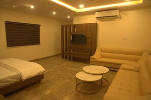 A modern bedroom with a bed, a sofa, and a small table.