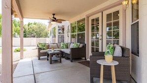 An outdoor patio with wicker furniture, a ceiling fan, and large windows. - ☀️🌵Tropical Desert Oasis. HEATED Pool & Spa no charge. Private, large yard 🌴🏜 (Glendale)