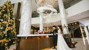 A hotel lobby with a marble reception desk, a Christmas tree, and a large chandelier. - Songlam Waterfront Hotel - 藍江酒店 (Nghi Xuân)