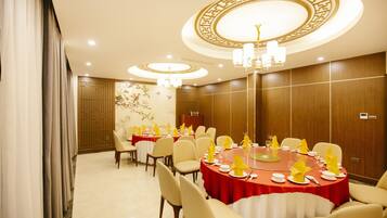 A conference room with round tables, chairs, and a chandelier.