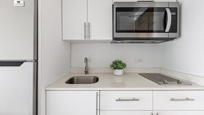 Une cuisine moderne équipée d’appareils électroménagers en acier inoxydable, d’un évier et d’une plante en pot.