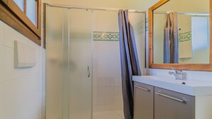 Un baño con ducha, inodoro y lavamanos.