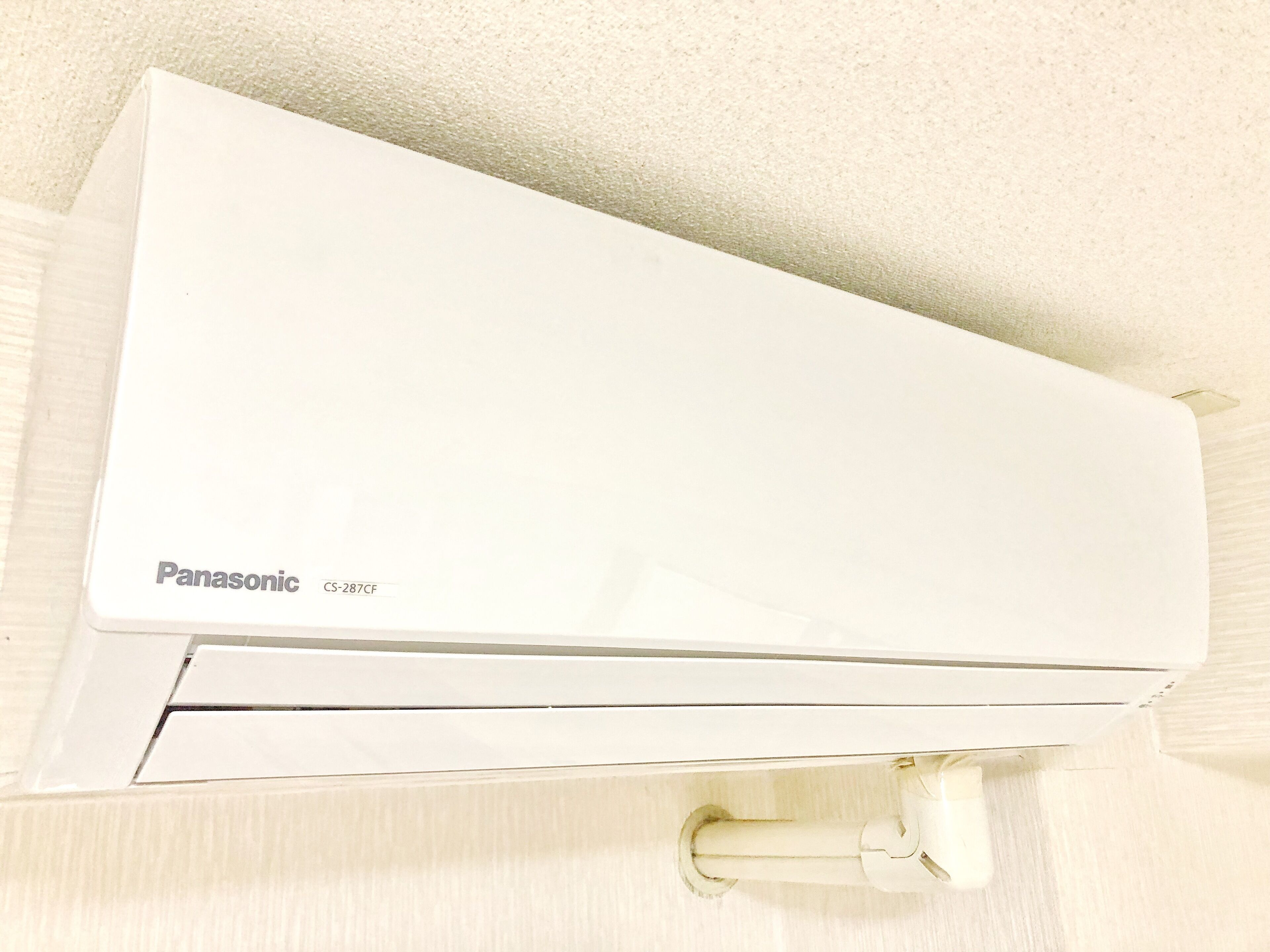 A white Panasonic air conditioning unit mounted on a wall.