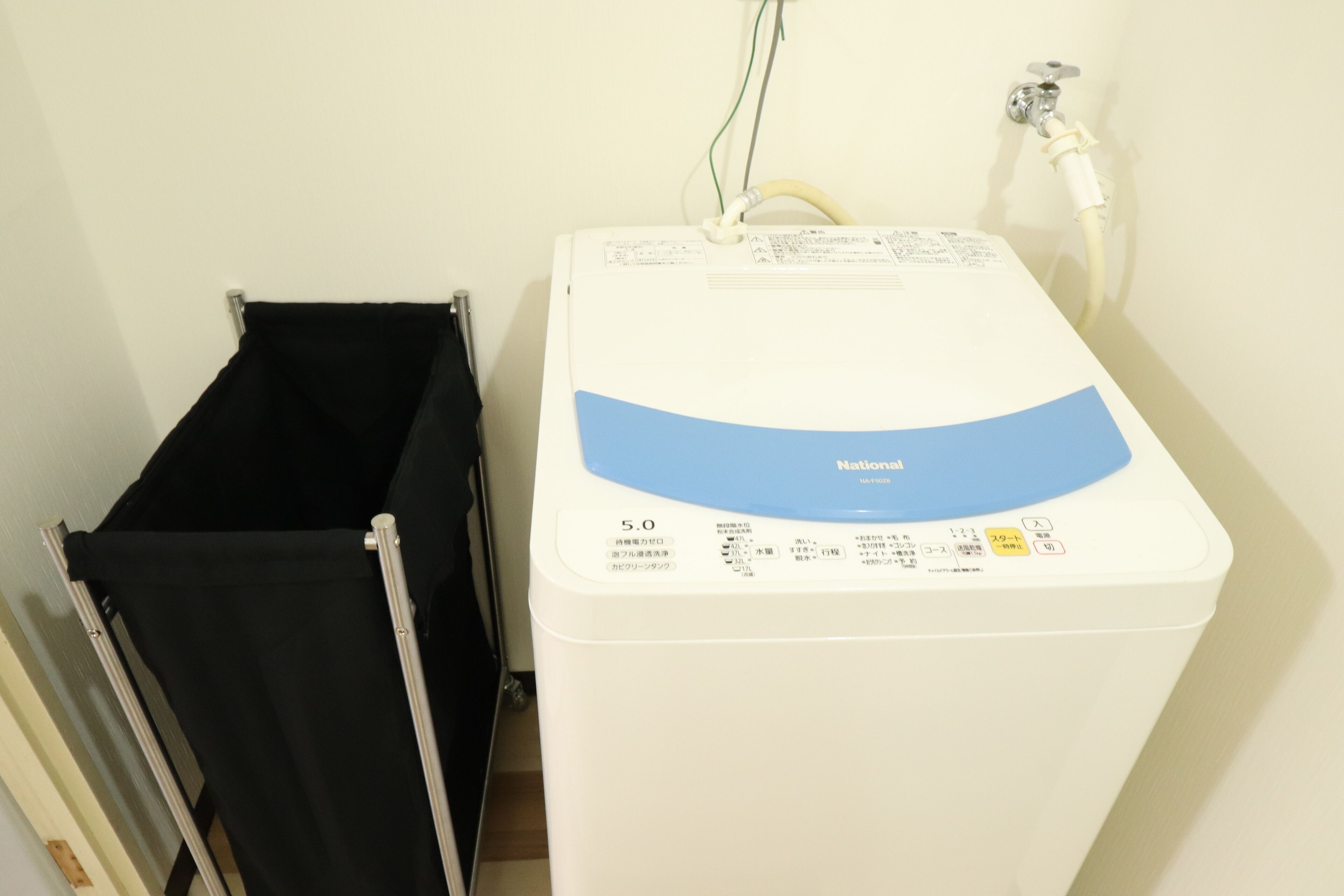 Een witte boiler met een blauw label en een bedieningspaneel.