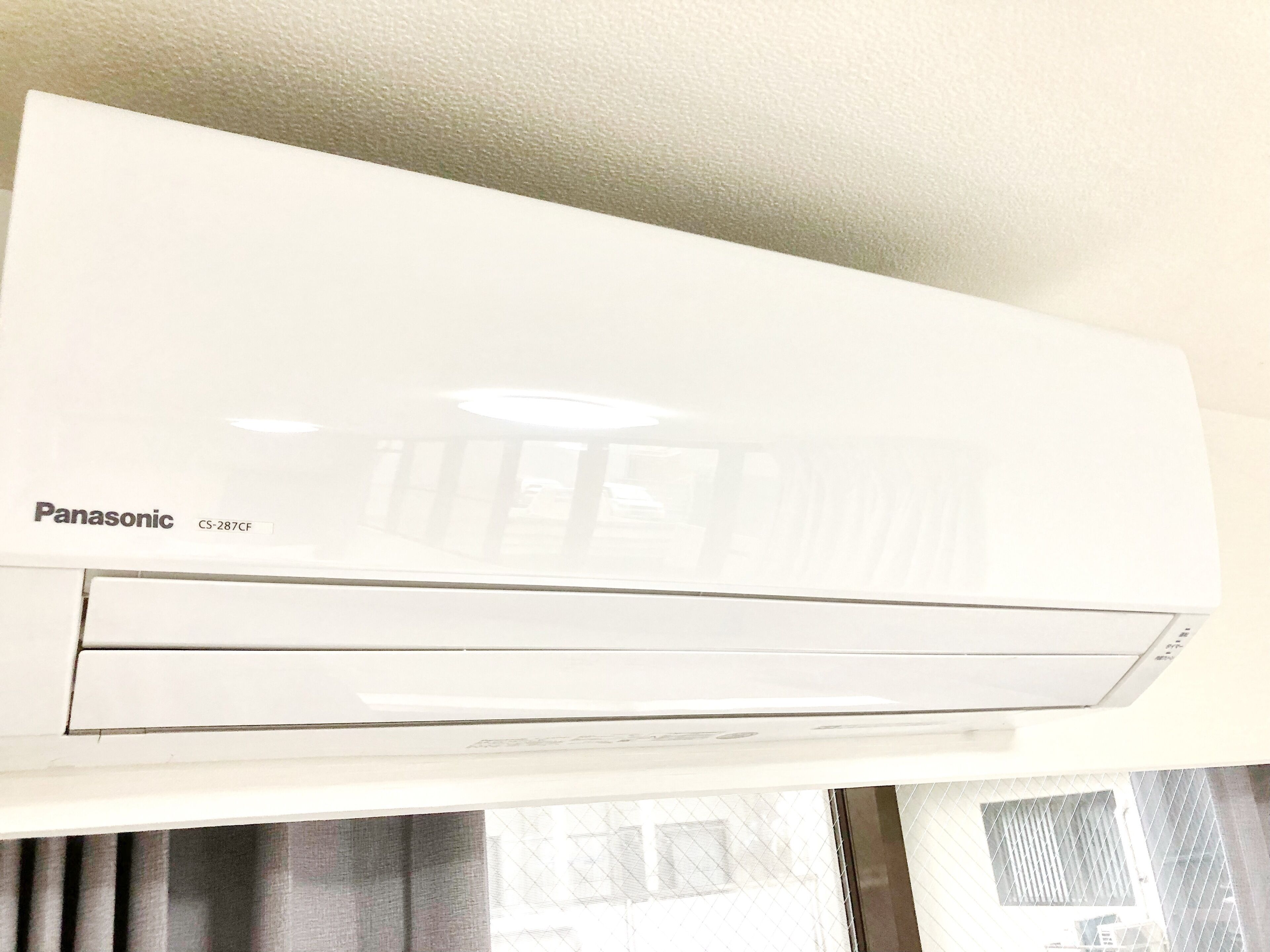A white Panasonic air conditioning unit mounted on a wall.