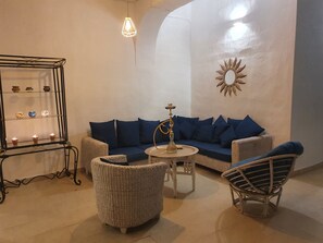 A living room with a sofa, two chairs, a small table, a decorative mirror, and a wall-mounted shelf with candles. - Villa "Tango" with Wi-Fi, Pool, Garden & Whirpool (Salobreña)