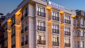 A multi-story hotel with a classic architectural design, featuring balconies and a well-lit facade. - Aspera Hotel Golden Horn (Istanbul)