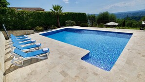 A rectangular swimming pool with a tiled edge, surrounded by beige tiles. - La Varlope (Grasse Plascassier)