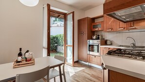 Eine moderne Küche mit Holzschränken, einem Gasherd und einem Essbereich mit Tisch und Stühlen.