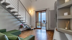 Ein modernes Interieur mit einer Treppe, einer grünen Sitzgruppe und Blick ins Freie.