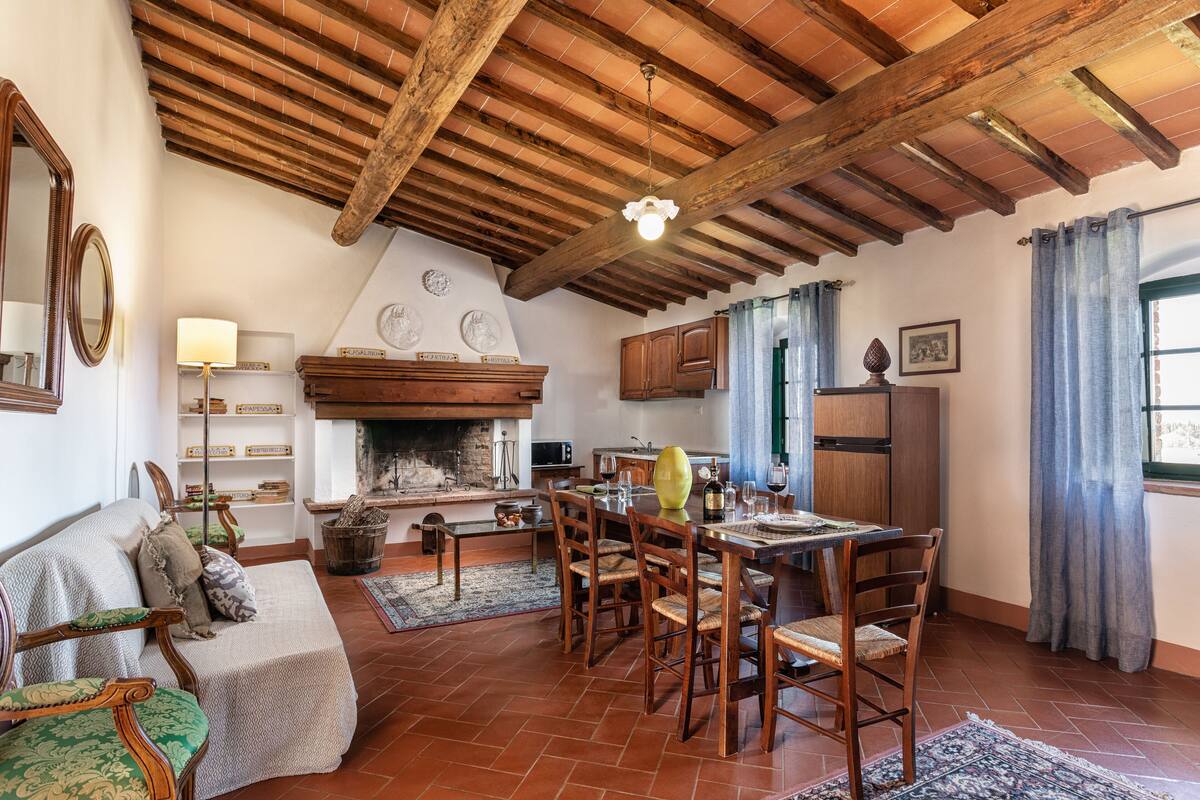 A rustic living room with a fireplace, wooden furniture, and a dining area.