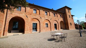 A historic building with arched doorways and a courtyard with outdoor seating.