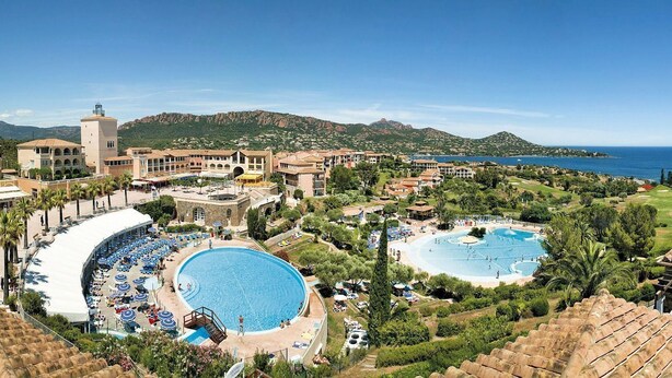 A resort with multiple swimming pools, a central courtyard, and a view of the sea and mountains. - Cap Esterel le village T2 Garden level-CLIM-Sea view-Pool and parking included (Saint-Raphaël)