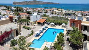 A resort with a swimming pool, sun loungers, and a view of the sea. - Ekavi Apartments (Chania)