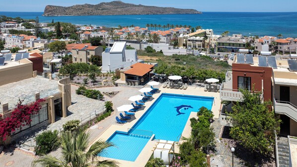 A resort with a swimming pool, sun loungers, and a view of the sea. - Ekavi Apartments (Chania)