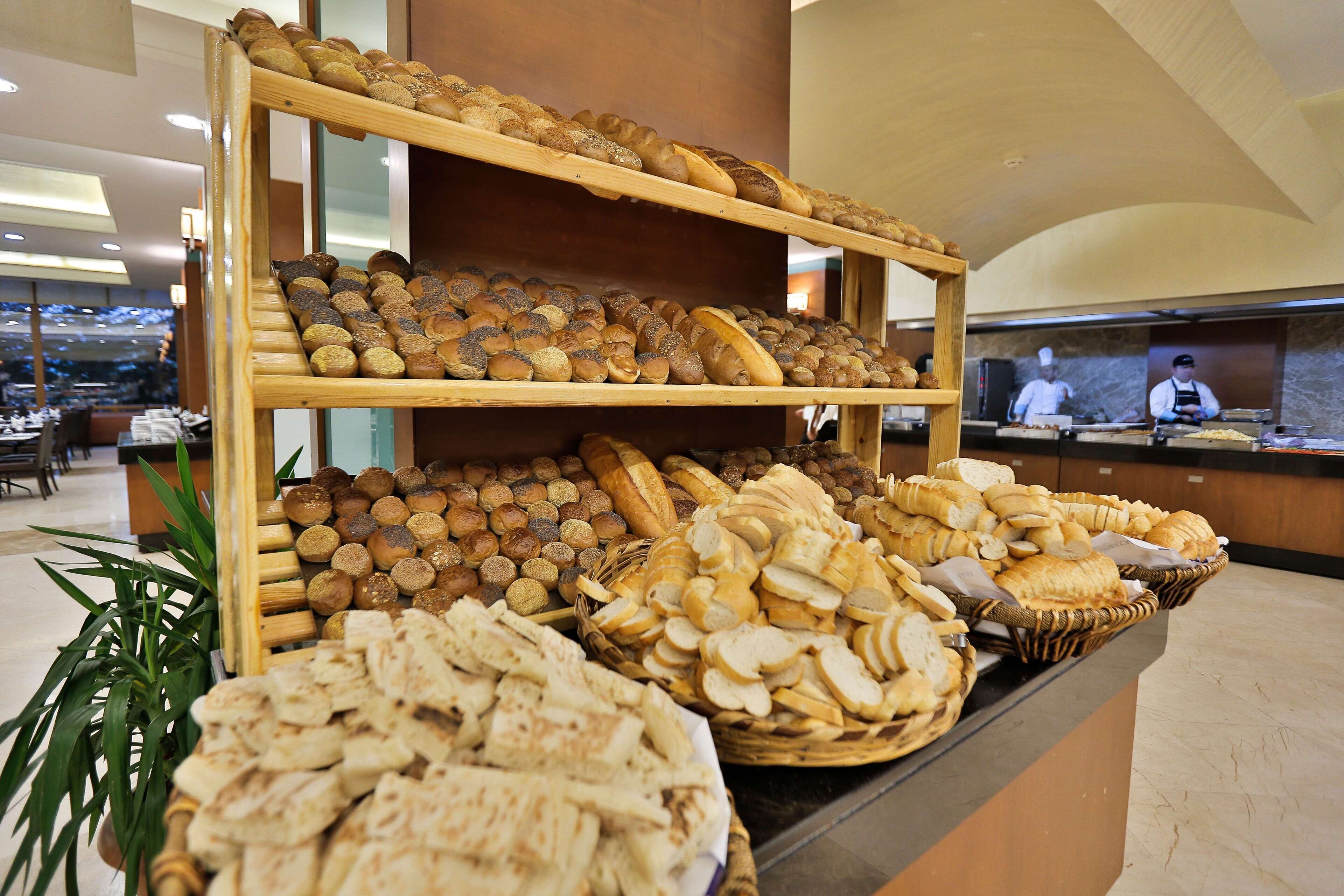 A buffet with various breads and pastries displayed on shelves and baskets.