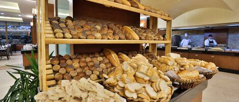 A buffet with various breads and pastries displayed on shelves and baskets.
