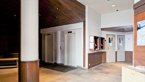 A modern lobby with a wooden ceiling, a reception desk, and a clean, tiled floor. - Courchevel La Tania, 2-room apartment with basement parking (Courchevel)