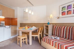 A compact living space with a kitchenette, a dining table with chairs, a sofa, and a small bookshelf. - Courchevel La Tania, 2-room apartment with basement parking (Courchevel)