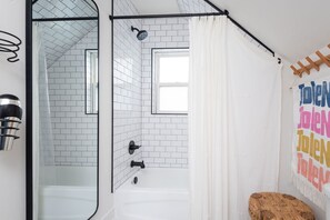 Bañera con ducha, secador de pelo, jabón, shampoo