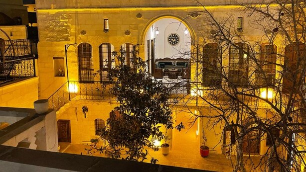 The exterior of the Tessa Hotel with a warm yellow lighting, stone facade, and an arched entrance leading to the lobby. - Tessera Hotel (Sanliurfa)