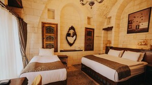 A room with two beds, a wooden desk, a chair, a chandelier, and a wall-mounted mirror. - Tessera Hotel (Sanliurfa)