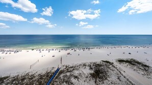 A beach with a clear sky, a sandy shore, and a blue ocean. - Updated Luxury Beachfront Condo w/ Pool, Sauna, & Fitness Center | Sleeps 8 (Gulf Shores)